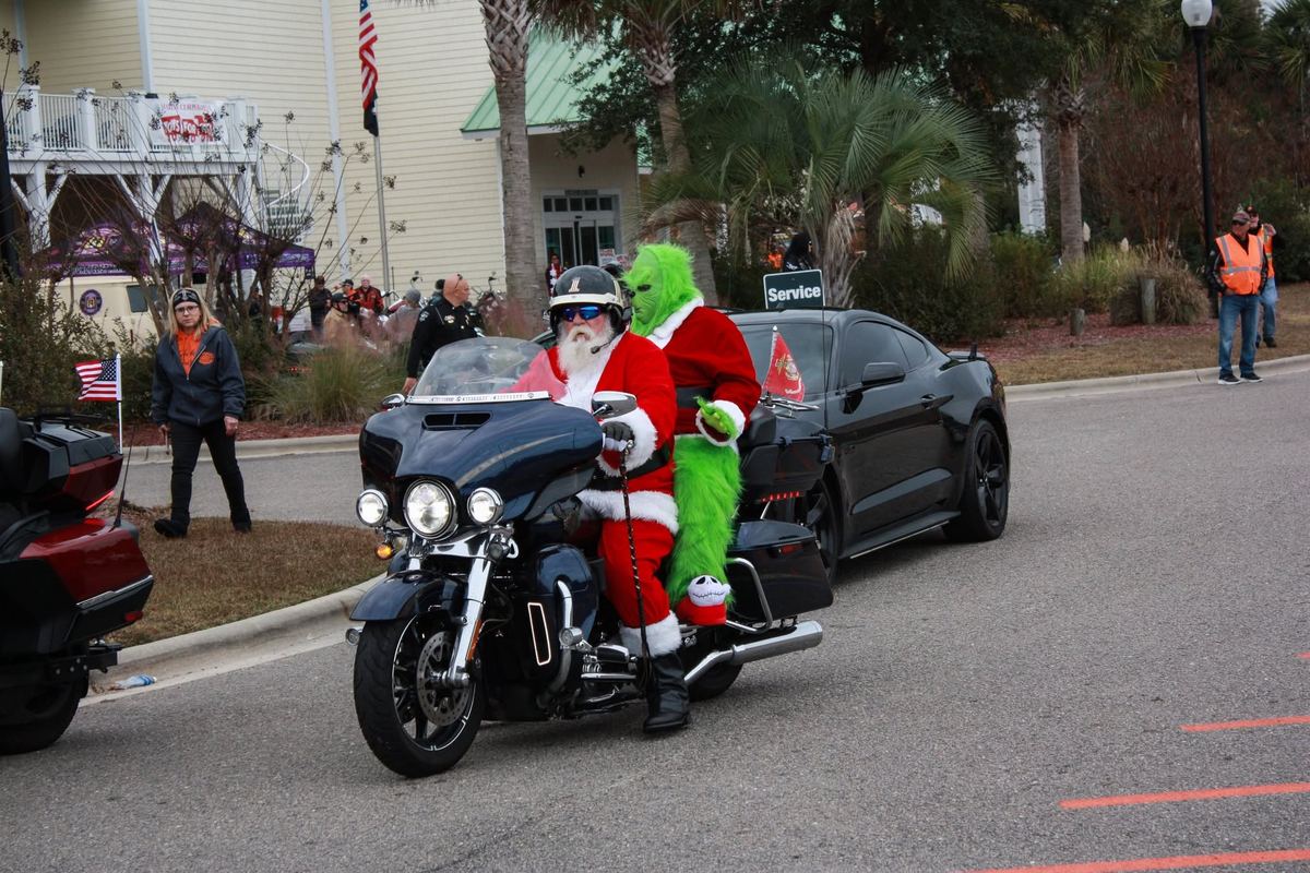 Santa and the Grinch riding a motorcycle at the 2025 Sea Breeze Harley-Davidson Toys for Tots Ride